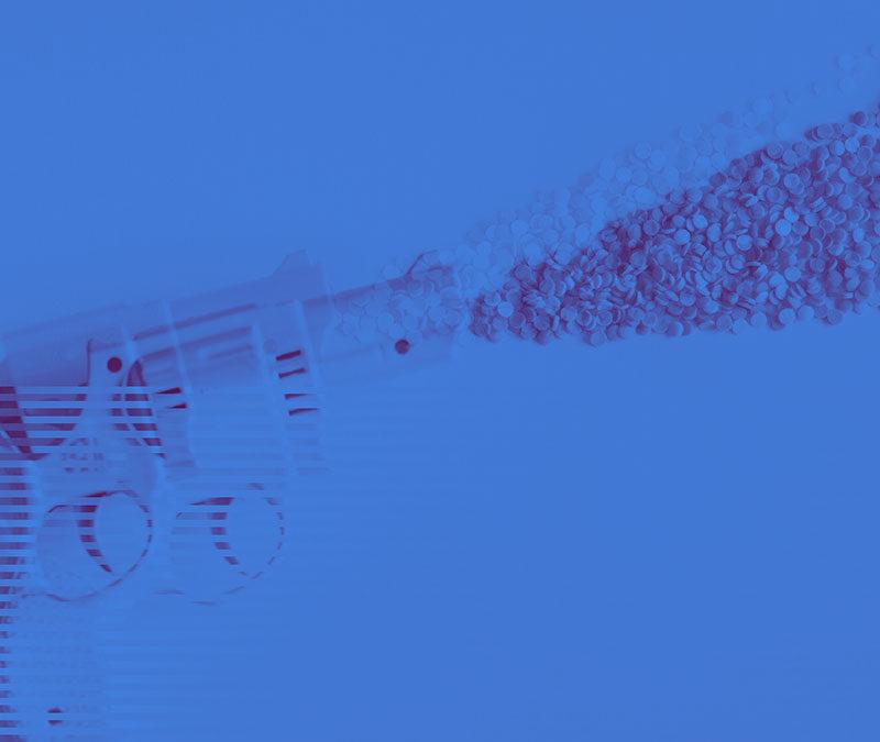 Revolver firing small pills under blue background