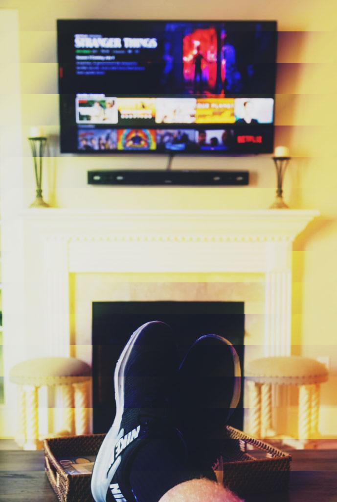 Person with their feet up on coffee table watching Netflix on TV
