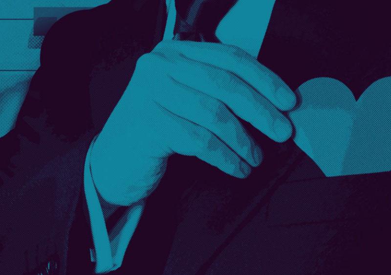 Man putting paper heart into front suit pocket