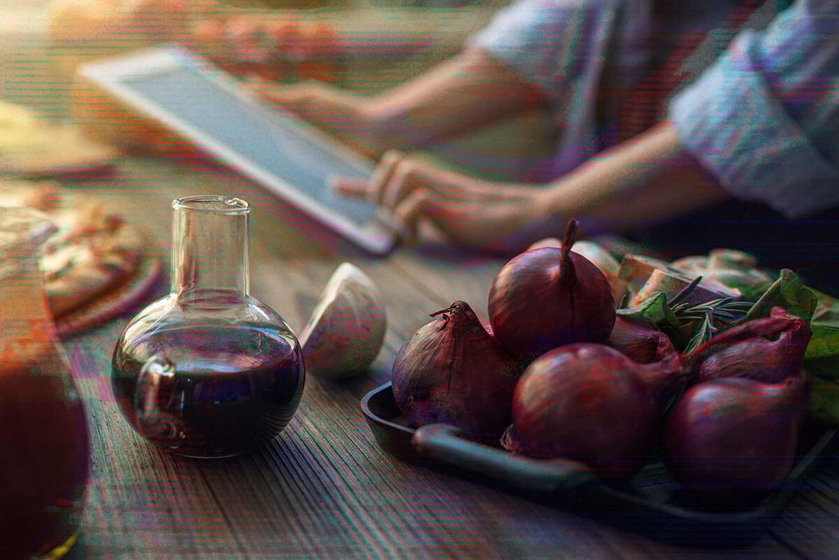 Food chopped up and prepared on countertop with women checking tablet