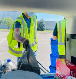 Man in high visibility vest loading groceries