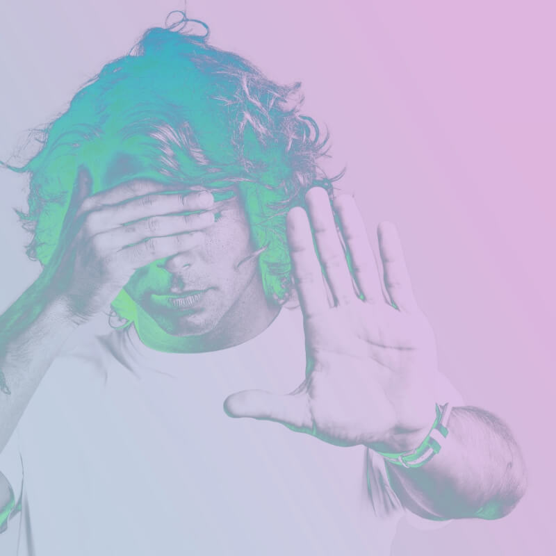 Colorized image of man covering eyes and hand in a stop signal
