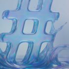 A translucent blue hashtag symbol rises from a swirling splash of liquid, with soft light creating a reflective, iridescent effect on the surface.